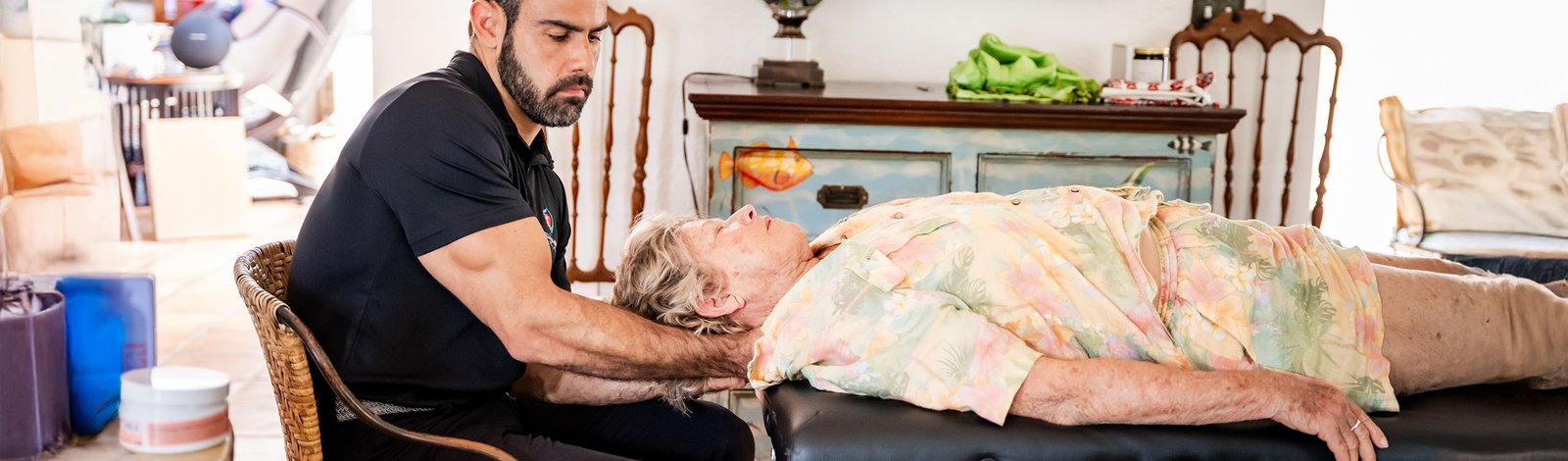 A Stellar physical therapist giving gentle hands-on therapy to an older woman at home